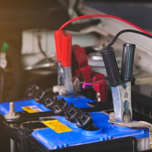 Charging battery car with electricity trough jumper cables,copy space.